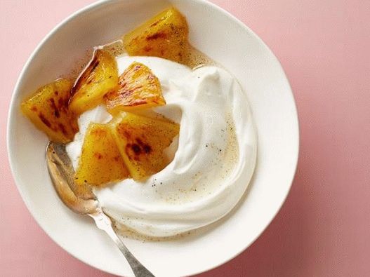 “照片希腊酸奶配橙色和蜂蜜糖浆的烤菠萝”