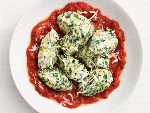 “西红柿酱菠菜和意大利乳清干酪饺子的照片”