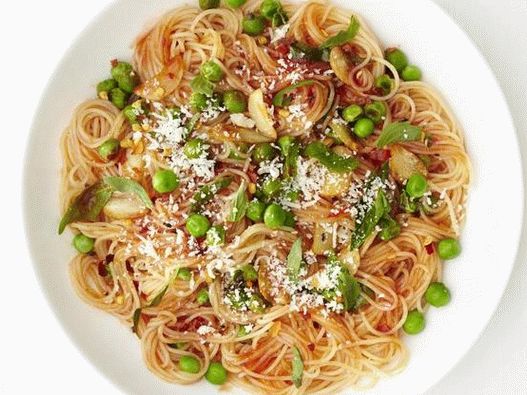 “意大利面食cappellini在大蒜和番茄酱与绿豌豆的照片”